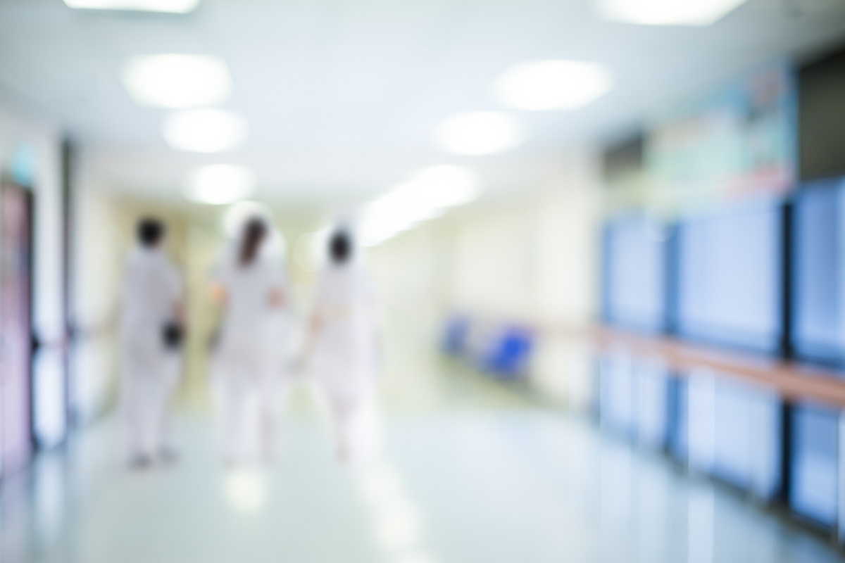 blurred out photo of hospital staff walking in a corridor