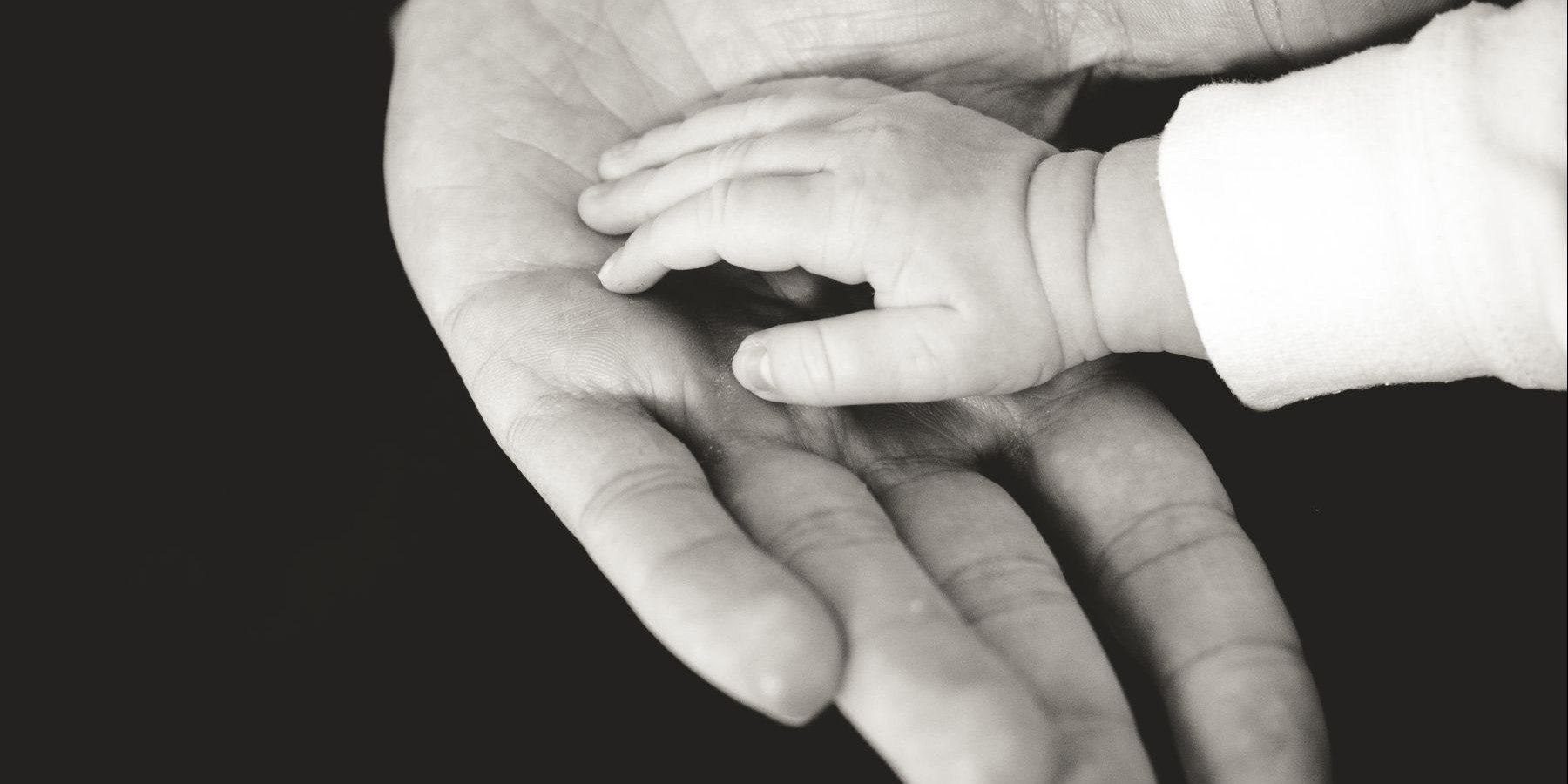 Child's hand in older person's hand